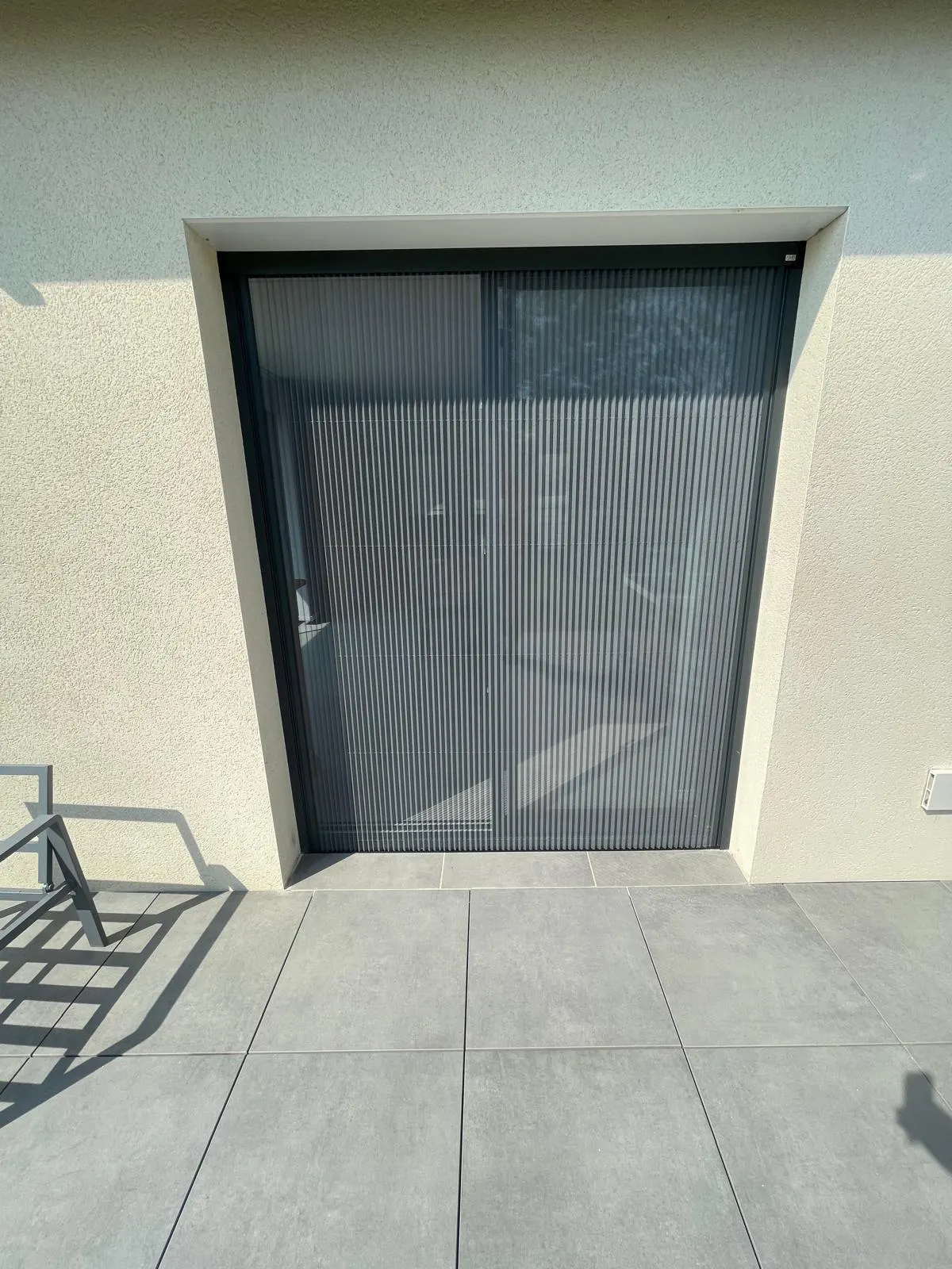 Moustiquaire plissée avec ossature en aluminium laquée gris anthracite avec toile fibre de verre grise