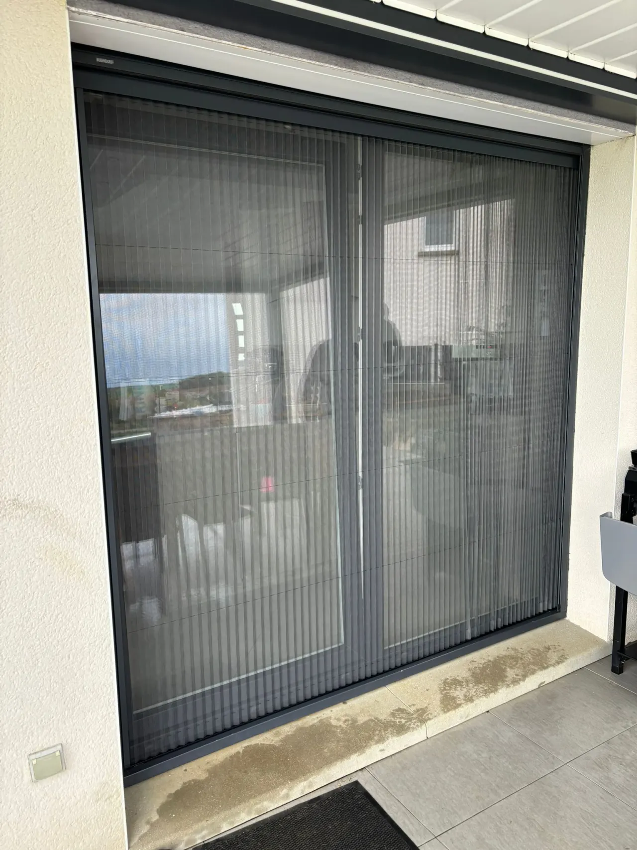Moustiquaire plissée avec ossature en aluminium laquée gris anthracite toile fibre de verre grise