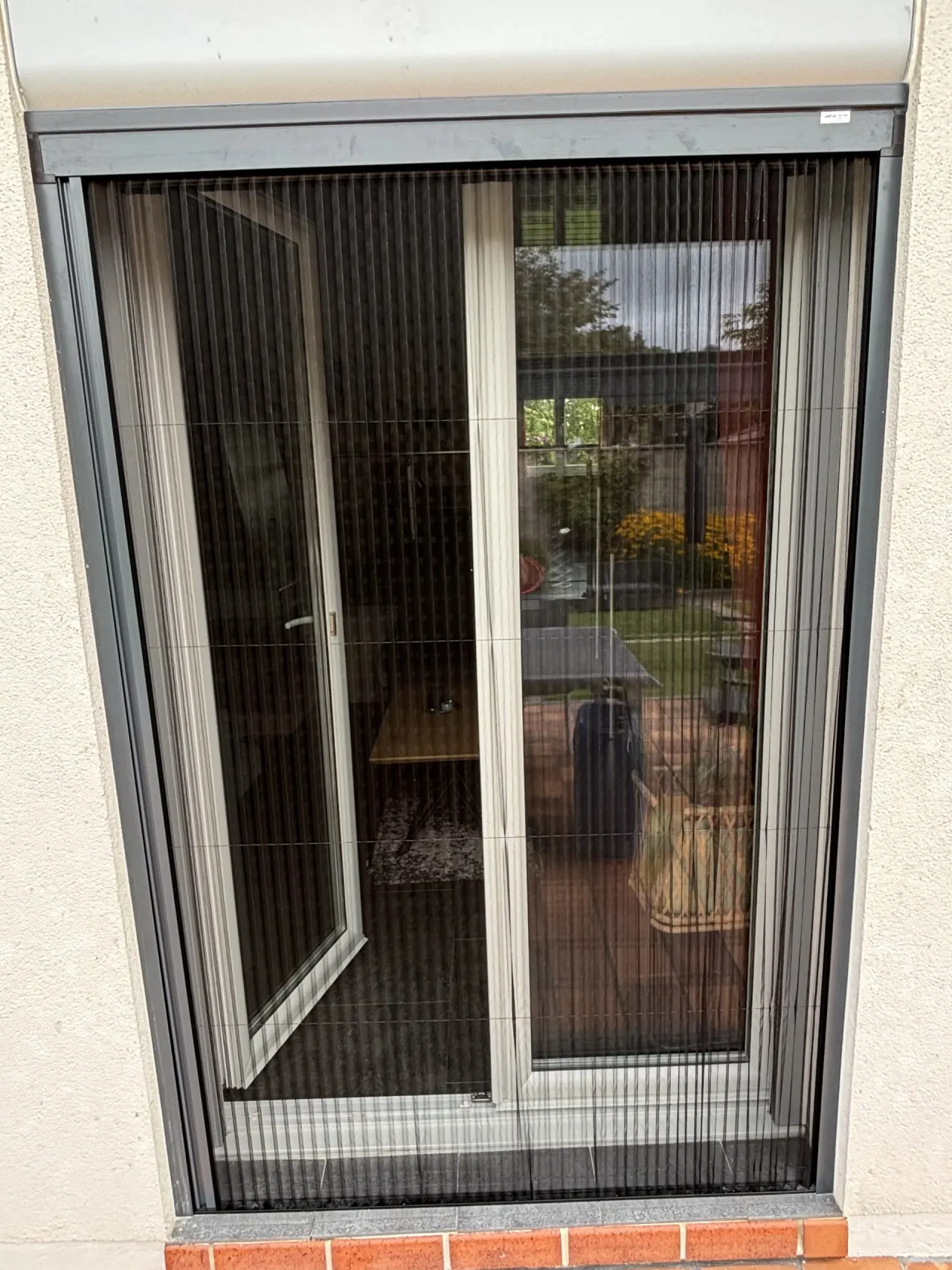 Moustiquaire plissée avec ossature en aluminium laquée gris anthracite avec toile fibre de verre grise
