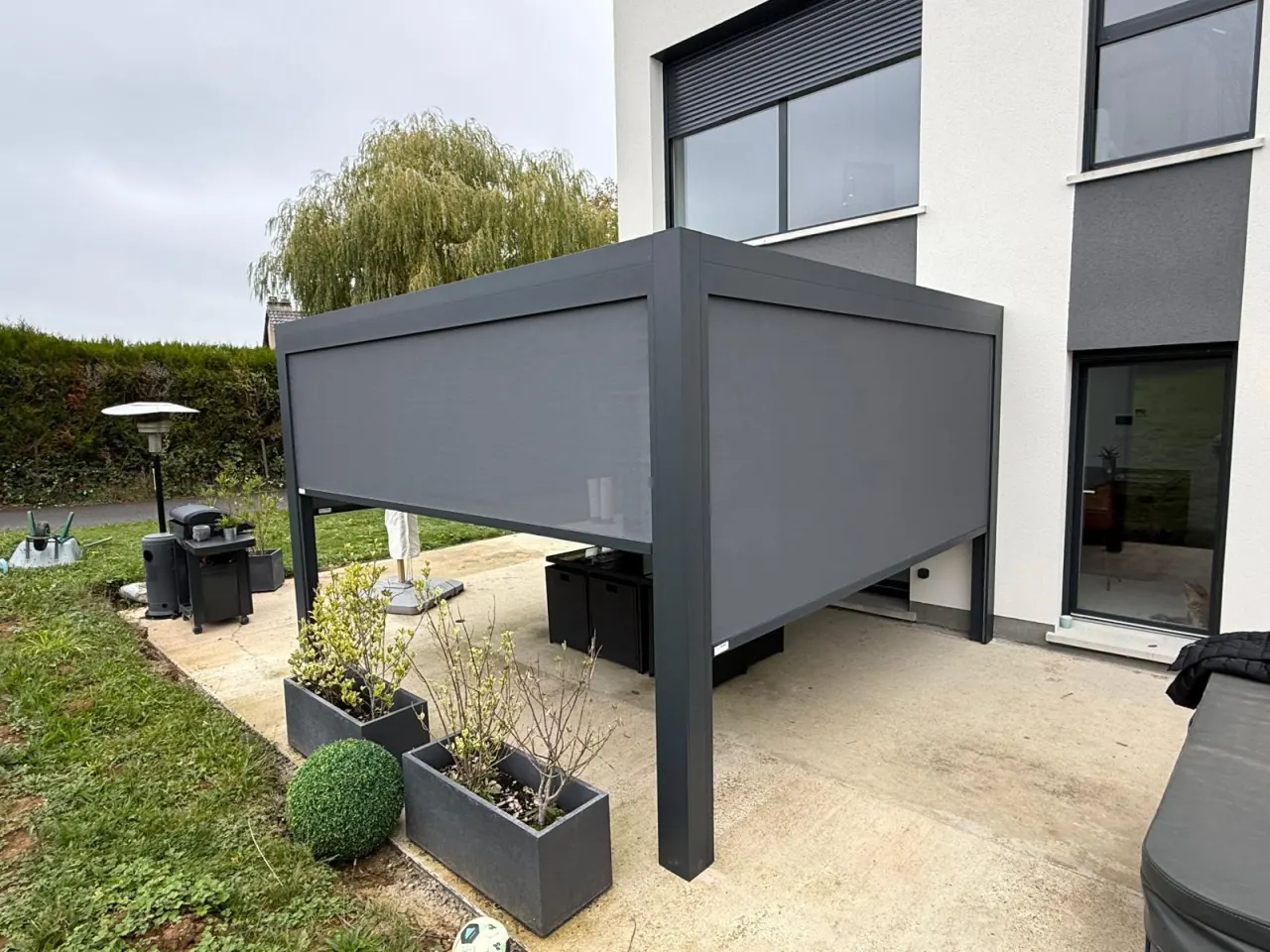 Store screen zip solaire coffre et toile Gris anthracite Pose sur pergola entre poteaux.