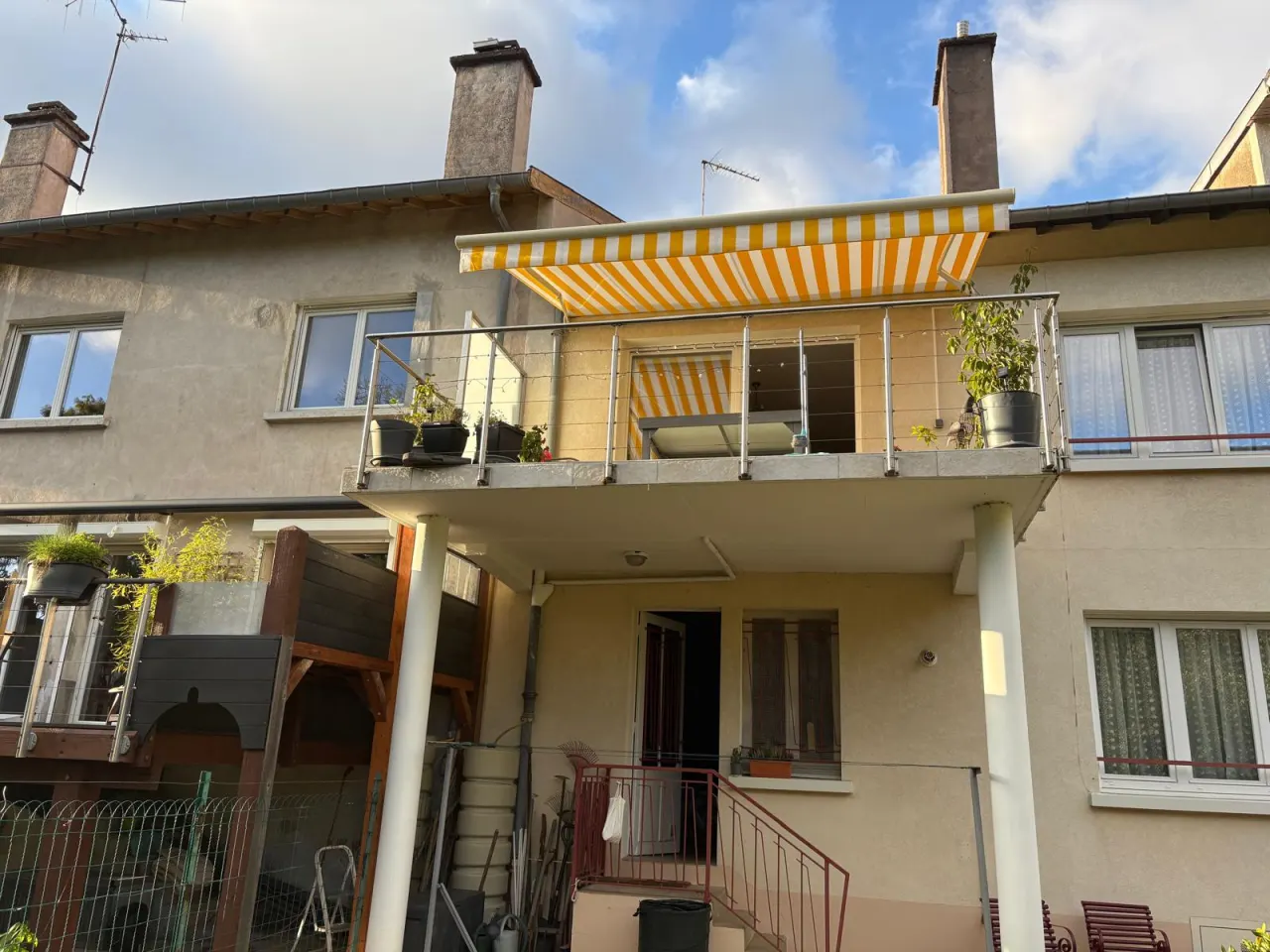 Store banne motorisé avec commande radio avec toile décorative jaune et blanche avec ossature blanche et bras avec leds intégrés