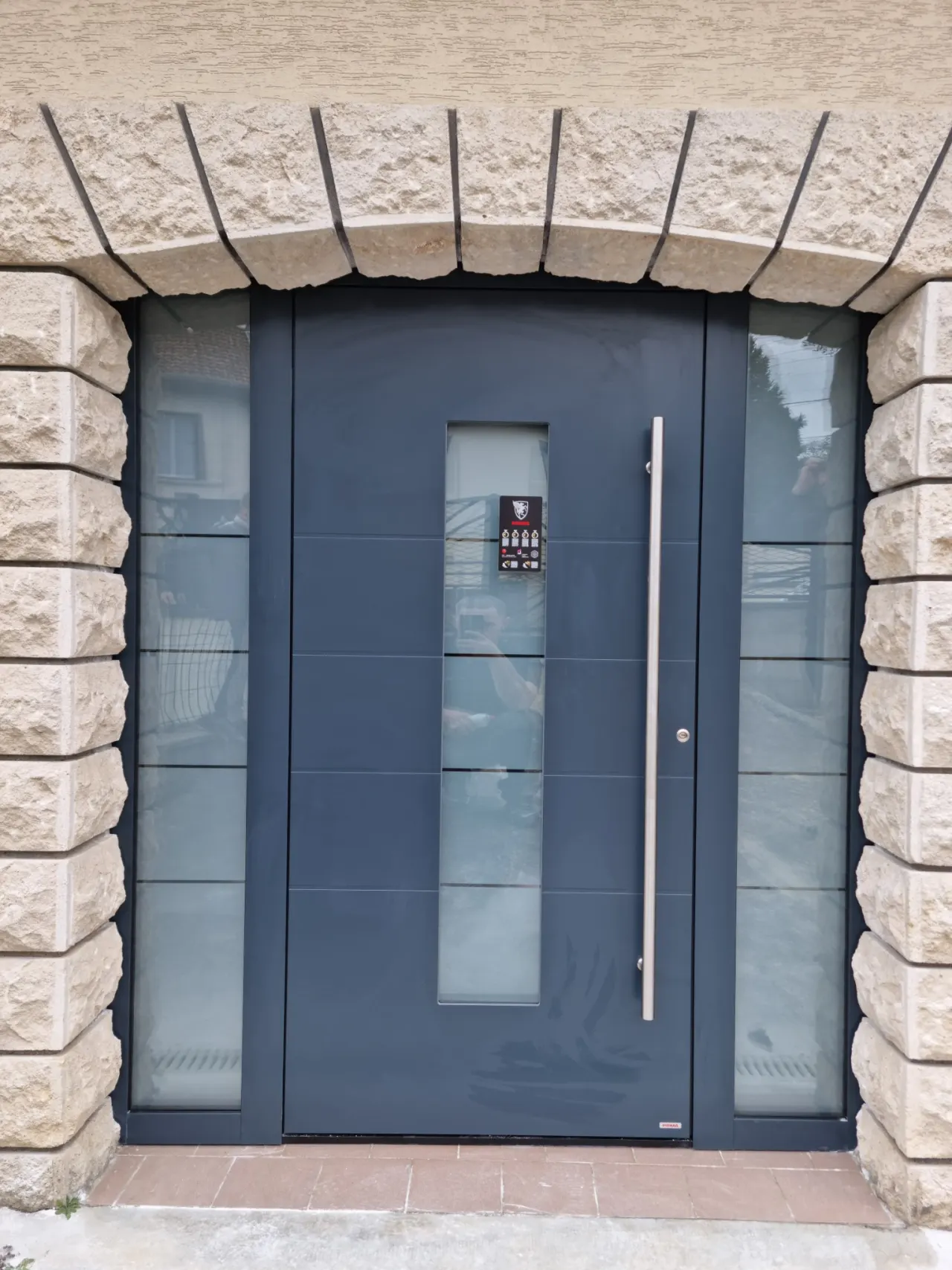 Porte d’entrée aluminium laqué Gris anthracite avec serrure 5 points barillet de sécurité avec isolation thermique barre de tirage hublots et impostes fixes latéraux vitrages sécurit