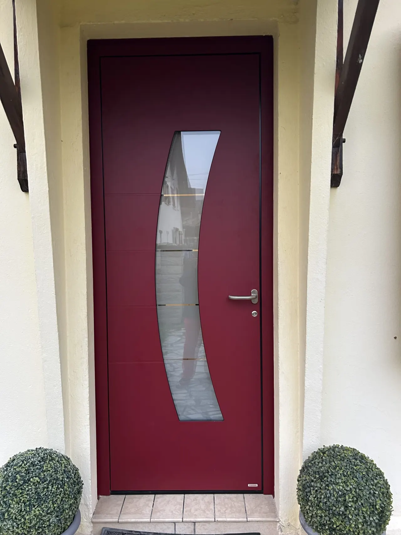 Porte d'entrée laquée rouge bordeaux avec serrure 5 points barillets de sécurité isolation thermique avec hublots en forme en demi lune