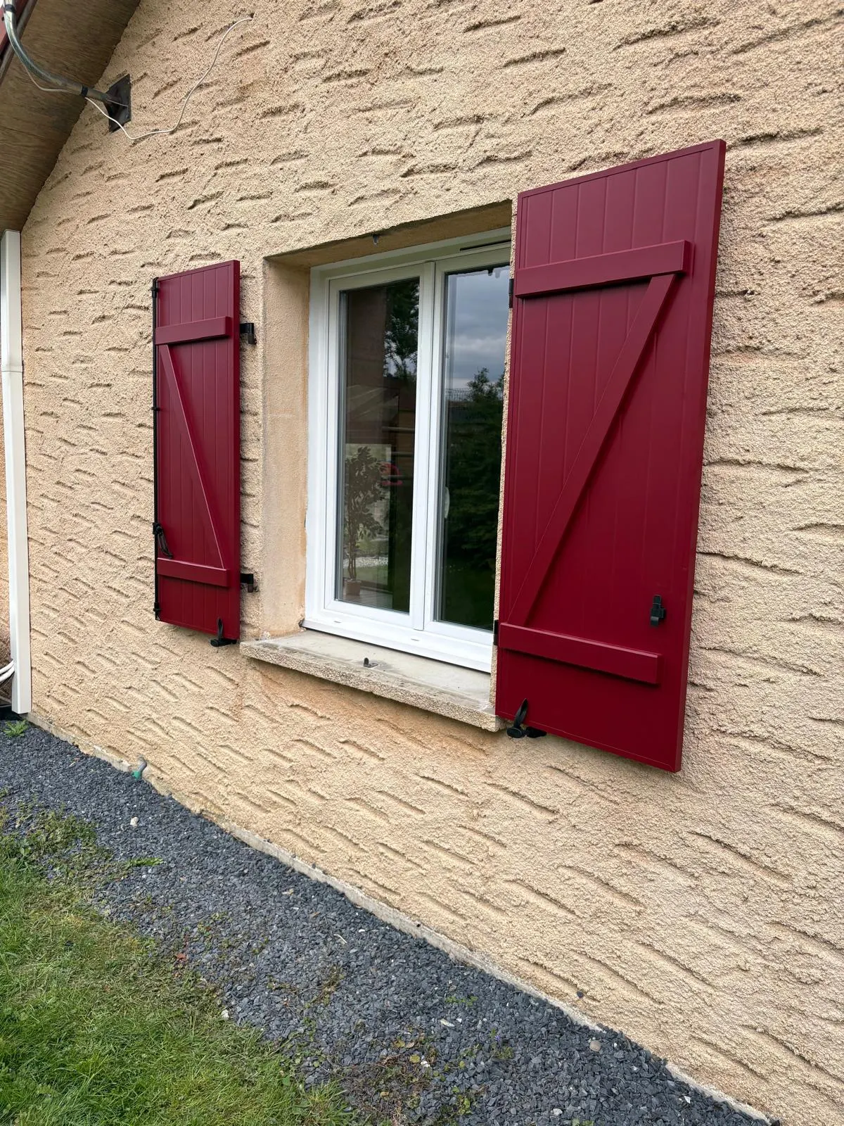 Volets battants en aluminium laqué rouge bordeaux avec une pose sur gonds existants