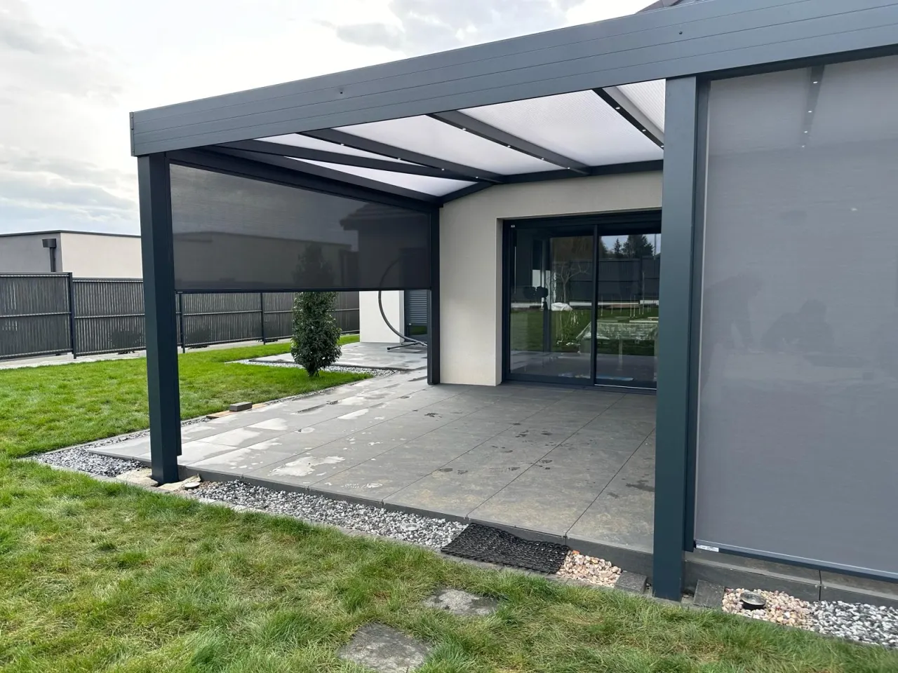 Pergola fixe avec ossature en aluminium laquée gris anthracite chevrons aluminium avec spots LEDS intégrés avec toiture panneaux polycarbonate 32mm