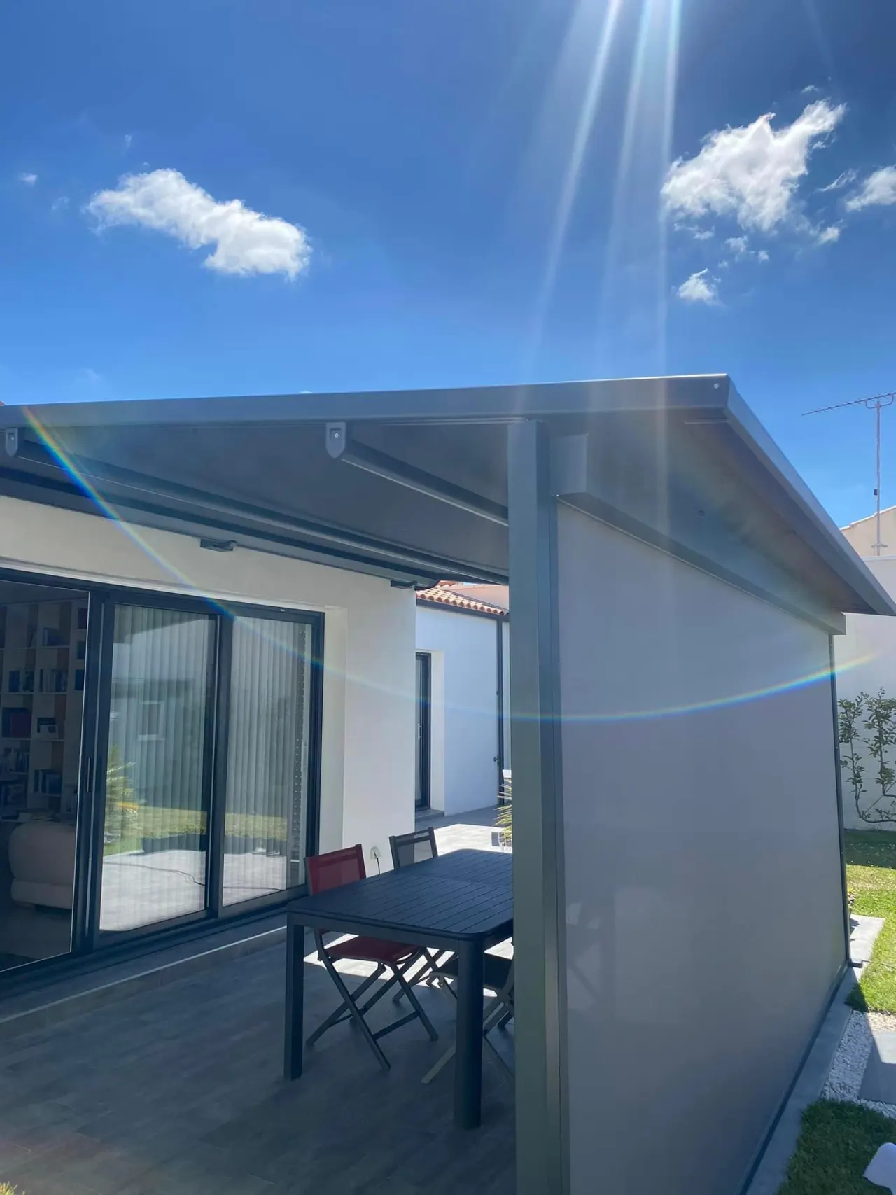 Pergola store avec ossature en aluminium laqué gris anthracite avec toile grise anthracite avec bandeau Led et store gris anthracite de façade