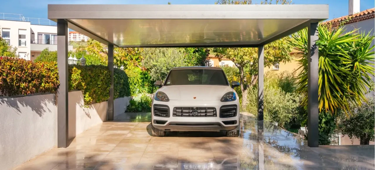 Carport autoportant à toit plat au-dessus d’un véhicule blanc