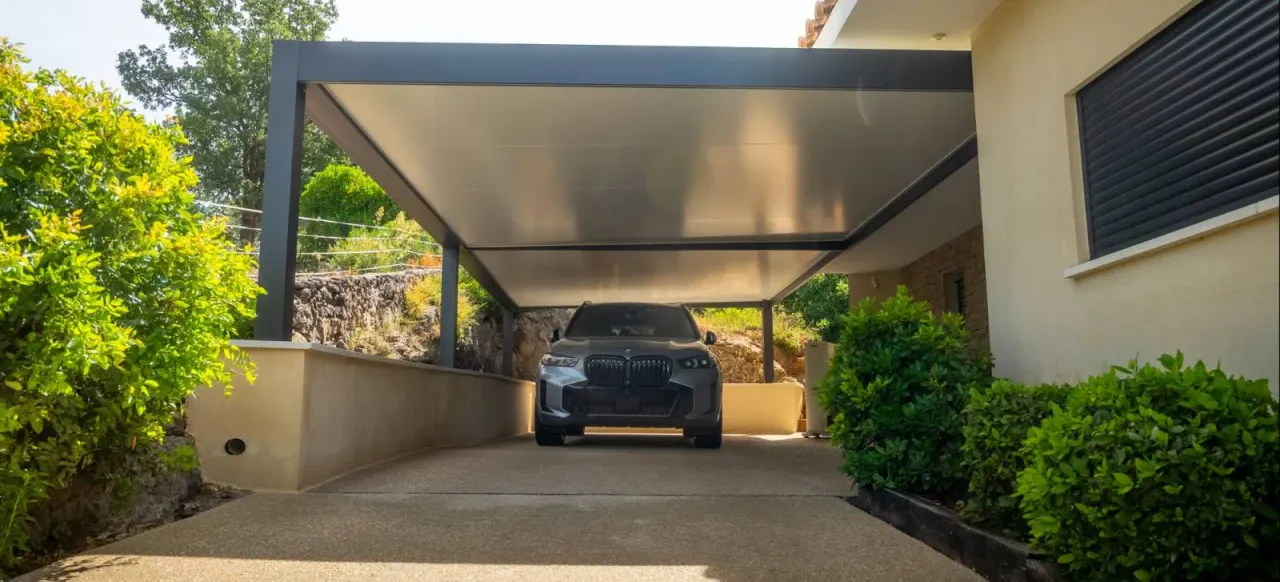 Carport accolé à une maison, ouvert sur l’allée