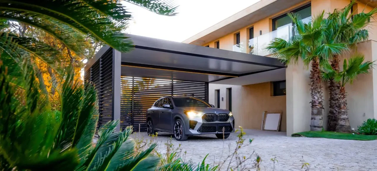 Carport contemporain avec un habillage à lames, à côté d’une maison