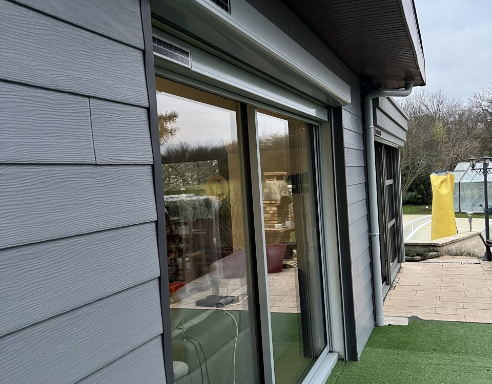 Fenêtre en aluminium laqué gris clair extérieur et blanc intérieur avec ouvrant et dormant renforcés avec volets roulants solaires