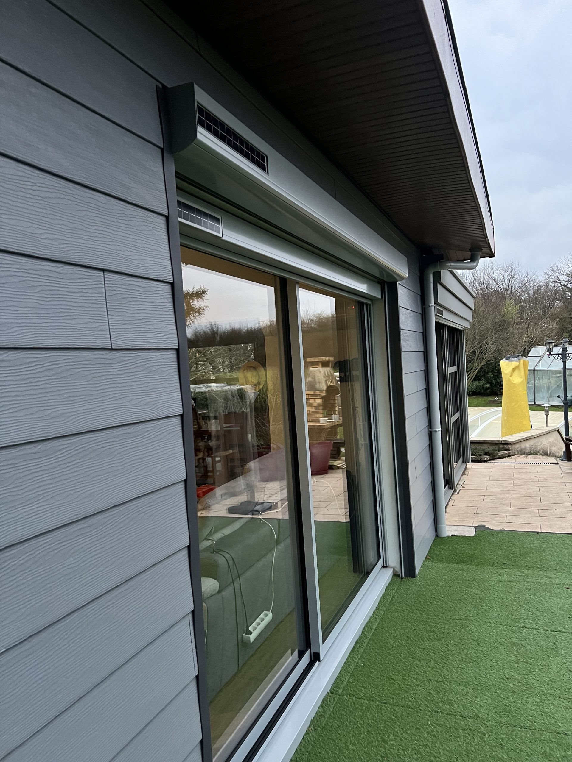 Fenêtre en aluminium laqué gris clair extérieur et blanc intérieur avec ouvrant et dormant renforcés avec volets roulants solaires