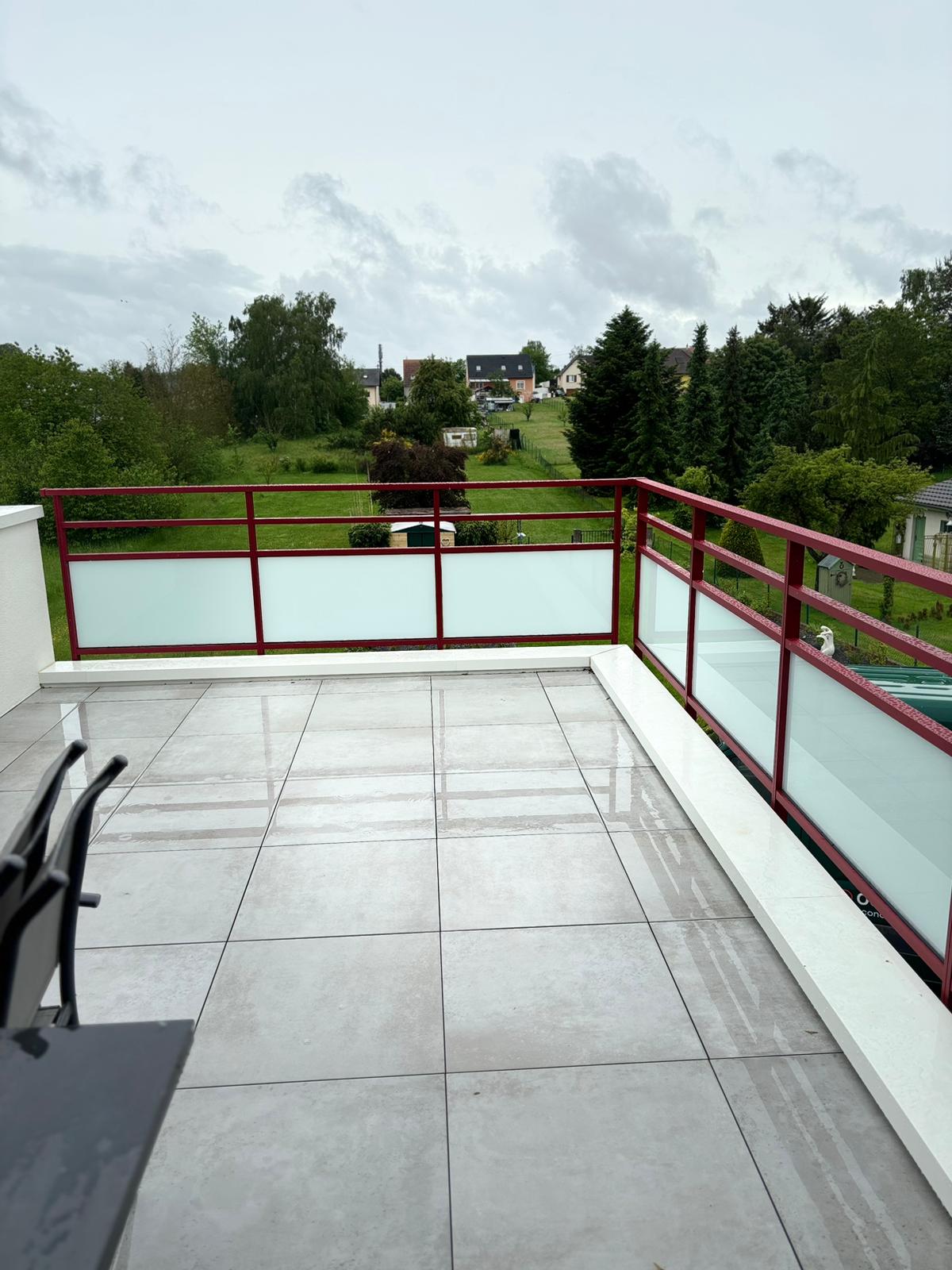 Garde corps en aluminium laqué rouge pourpre avec barreaudage verticale et horizontal avec vitrage dépoli en sous bassement et une pose sur dalle