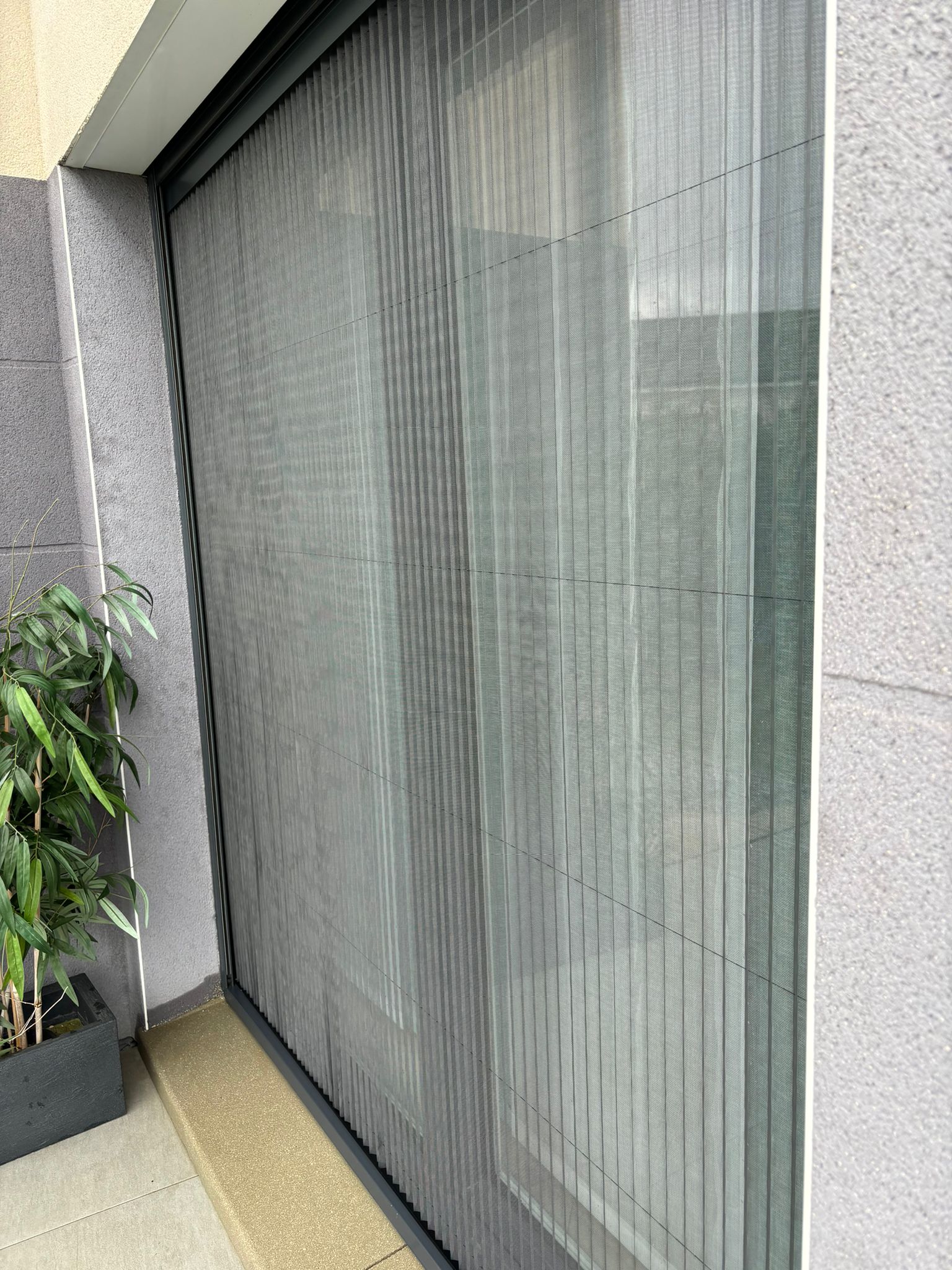 Moustiquaire plissée avec ossature en aluminium laquée gris anthracite avec toile fibre de verre grise
