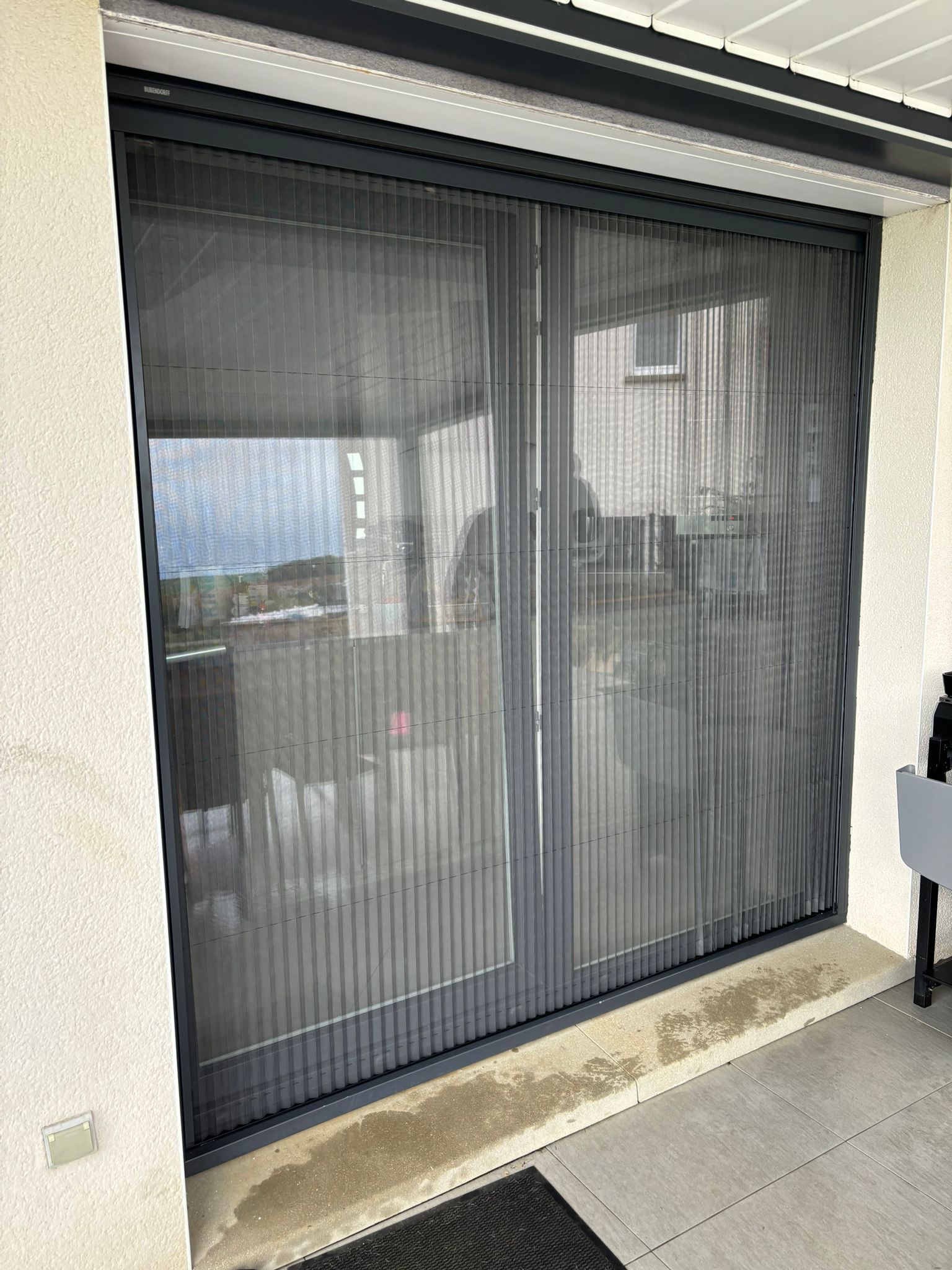 Moustiquaire plissée avec ossature en aluminium laquée gris anthracite toile fibre de verre grise