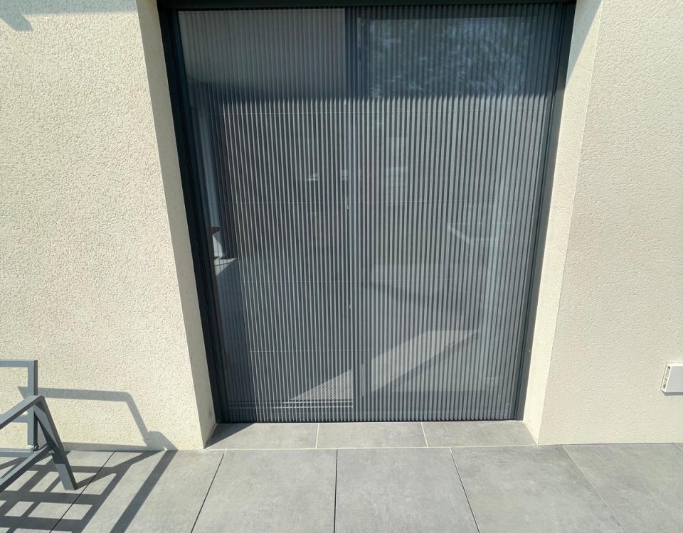 Moustiquaire plissée avec ossature en aluminium laquée gris anthracite avec toile fibre de verre grise