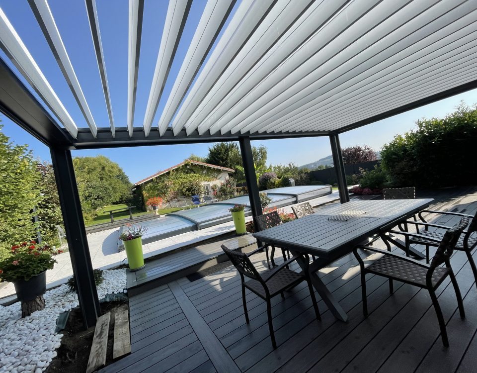 Pergola bioclimatique avec ossature en aluminium laquée gris anthracite avec lames orientables laquées blanc