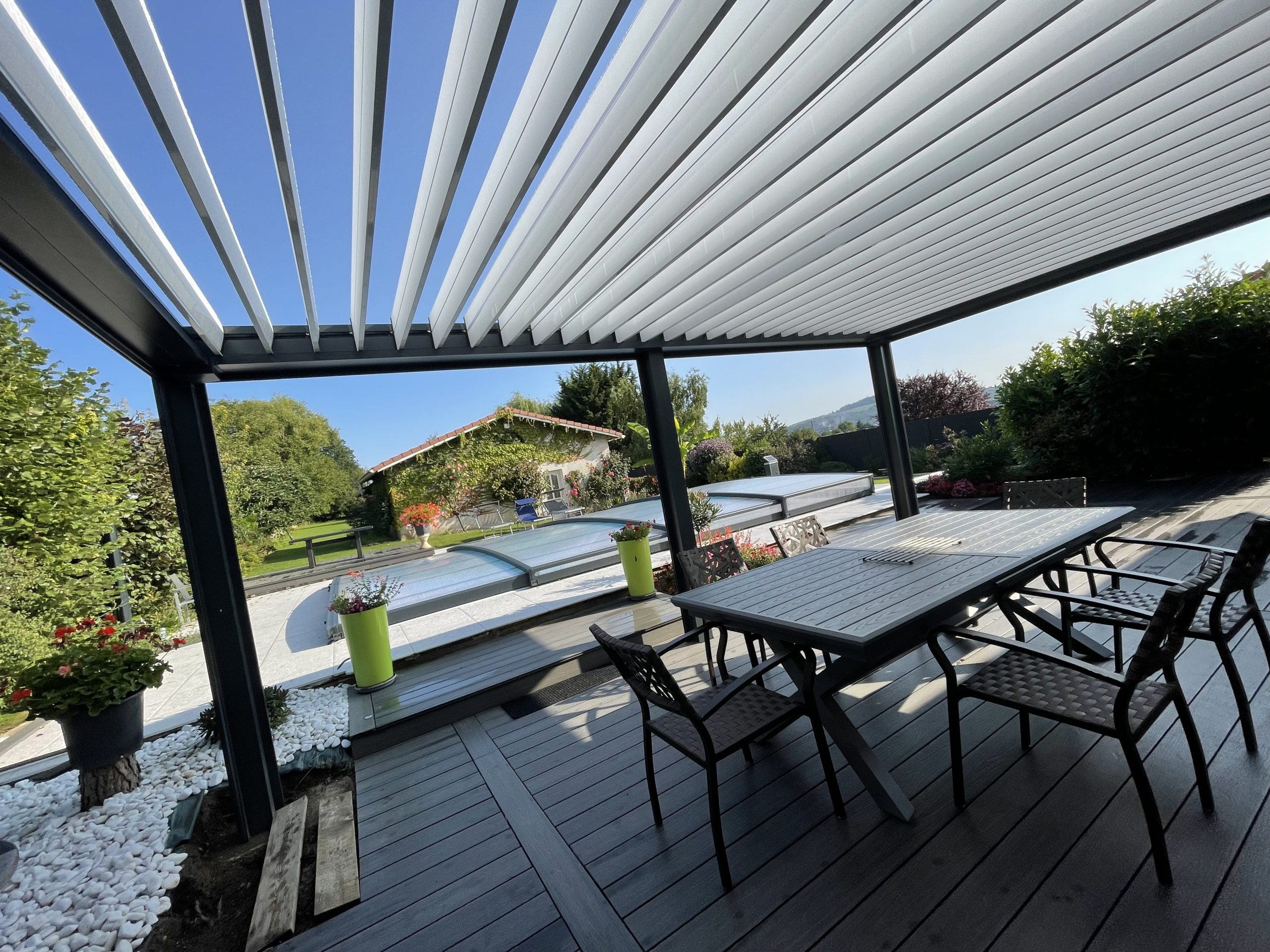 Pergola bioclimatique avec ossature en aluminium laquée gris anthracite avec lames orientables laquées blanc