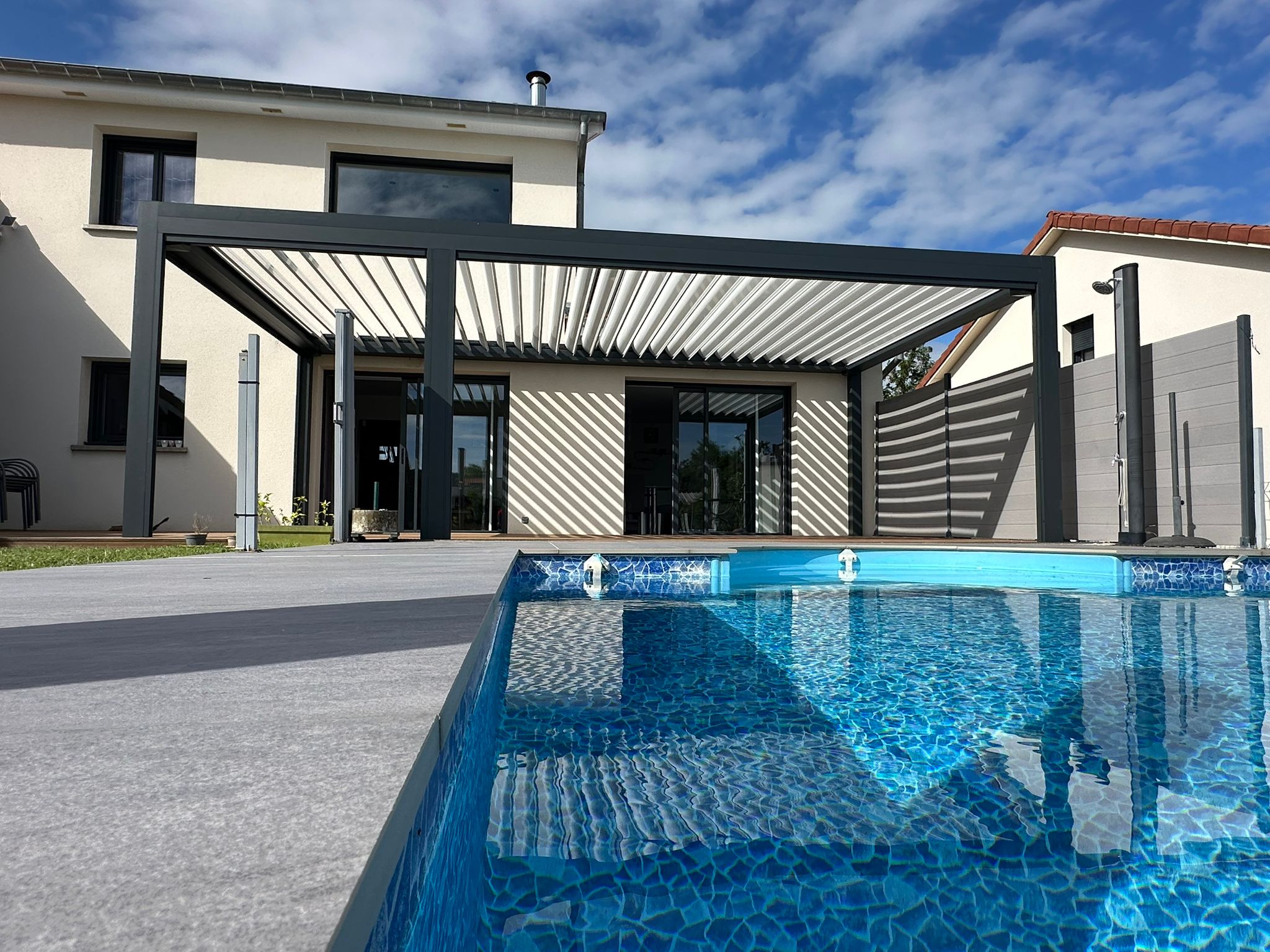 Pergola bioclimatique avec ossature en aluminium laqué gris anthracite avec Lames orientables en aluminium laquées blanc