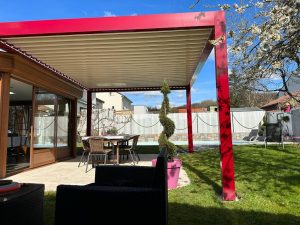 Pergola bioclimatique avec ossature en aluminium rouge avec lames orientables blanches en aluminium