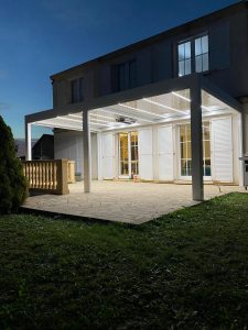 Pergola bioclimatique avec ossature en aluminium laquée blanc avec lames orientables laquées blanc et éclairage leds blanc intégré dans les lames