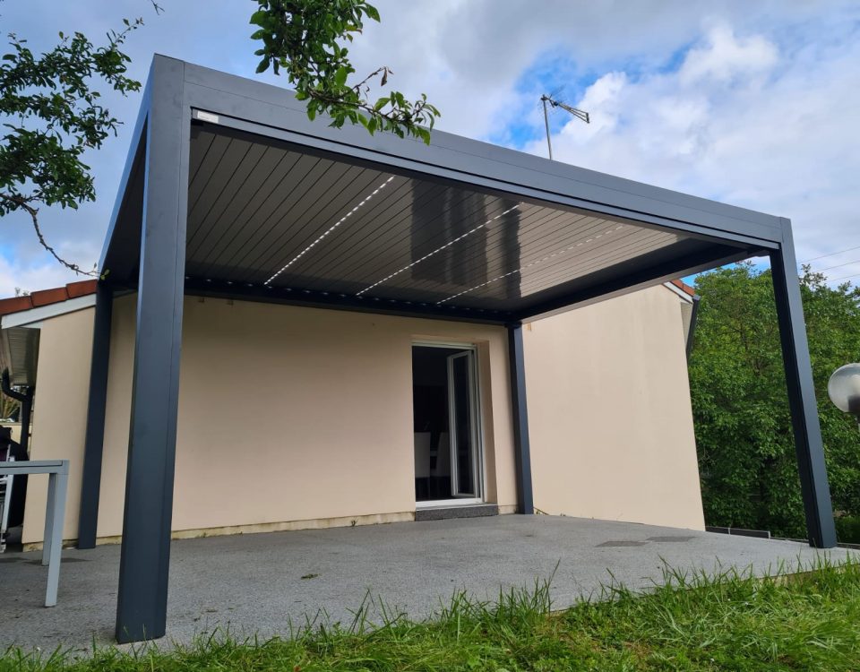 Pergola bioclimatique avec ossature en aluminium laqué gris anthracite avec lames orientables en aluminium laqué blanc avec éclairage leds intégré