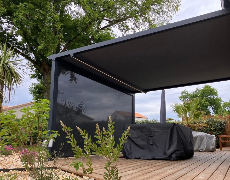 Pergola store avec ossature en aluminium laqué gris anthracite avec toile grise anthracite avec bandeau led avec store gris anthracite en façade