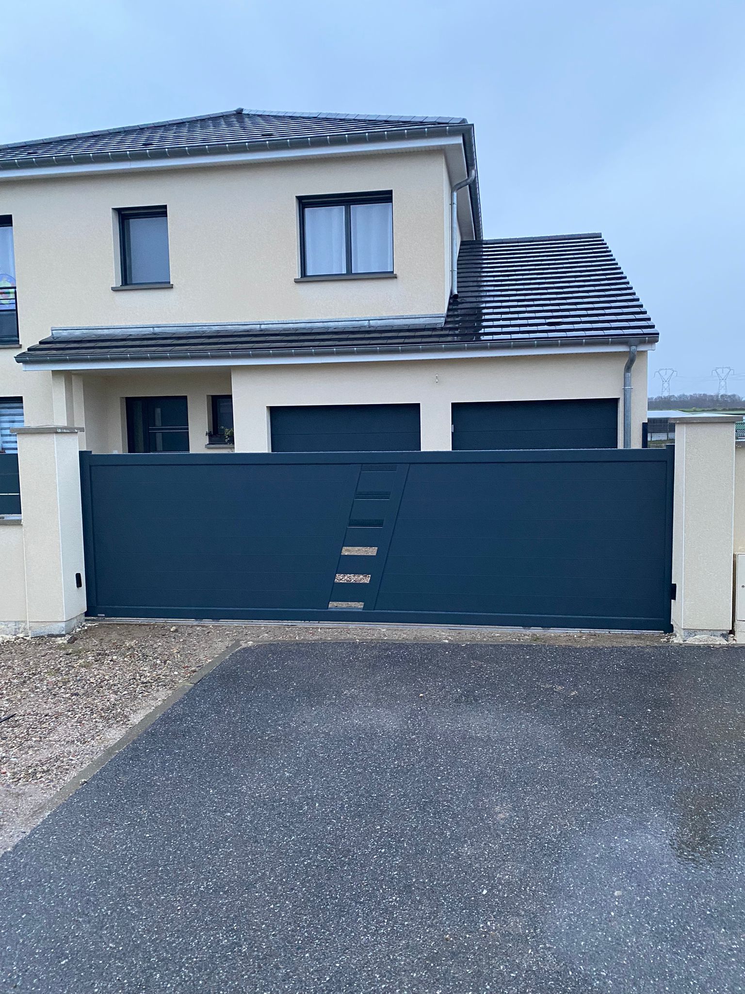 Portai coulissant motorisé en aluminium laqué gris anthracite avec panneau plein et ajouré