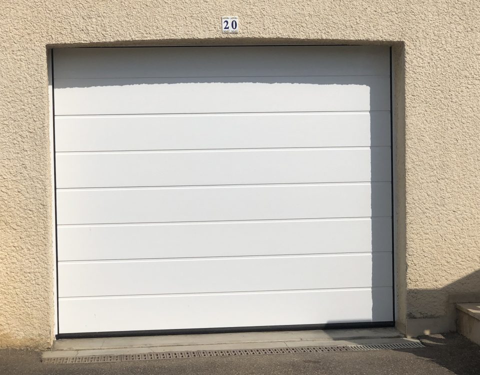 Porte de garage sectionnelle en aluminium laqué blanc avec épaisseur de 42 mm isolante avec manoeuvre motorisée et design lisse