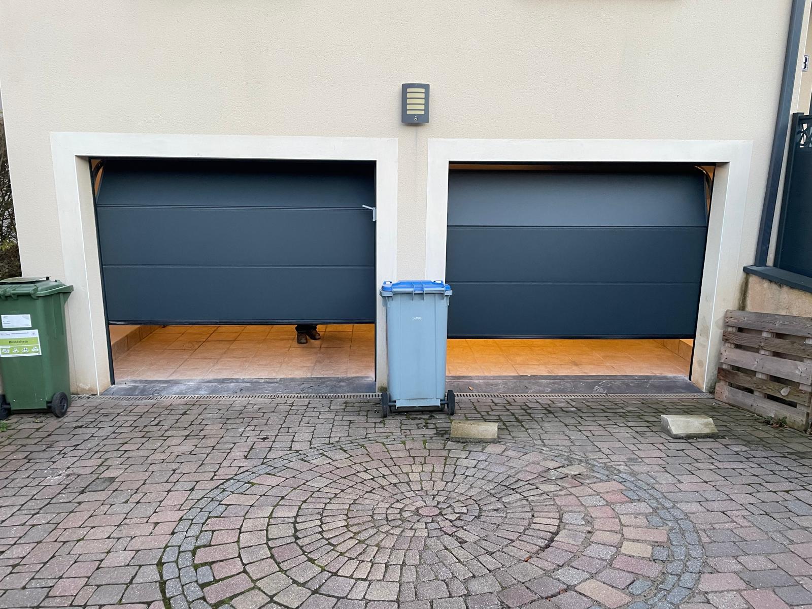 Portes de garages sectionnelles en aluminium laquées gris anthracite avec manoeuvre motorisée et design lisse
