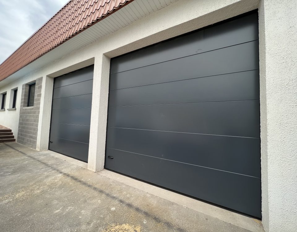 Portes de garages sectionnelles en aluminium laquées gris anthracite avec manoeuvre motorisée et design lisse