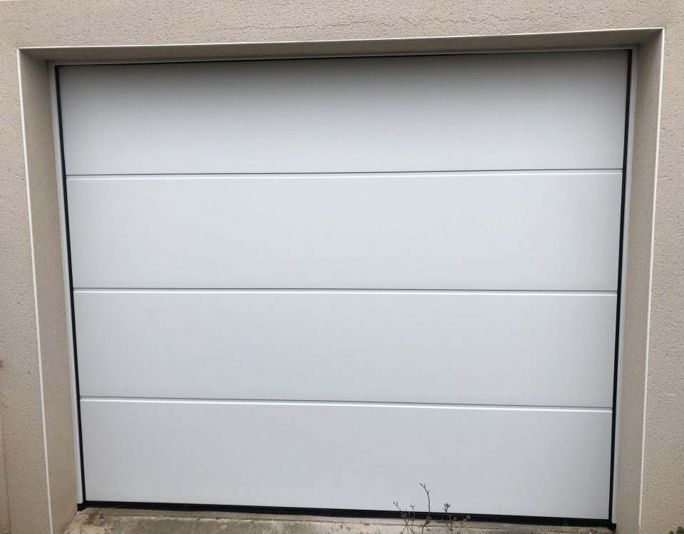 Porte de garage sectionnelle en aluminium laquée blanc avec manoeuvre motorisée et design lisse