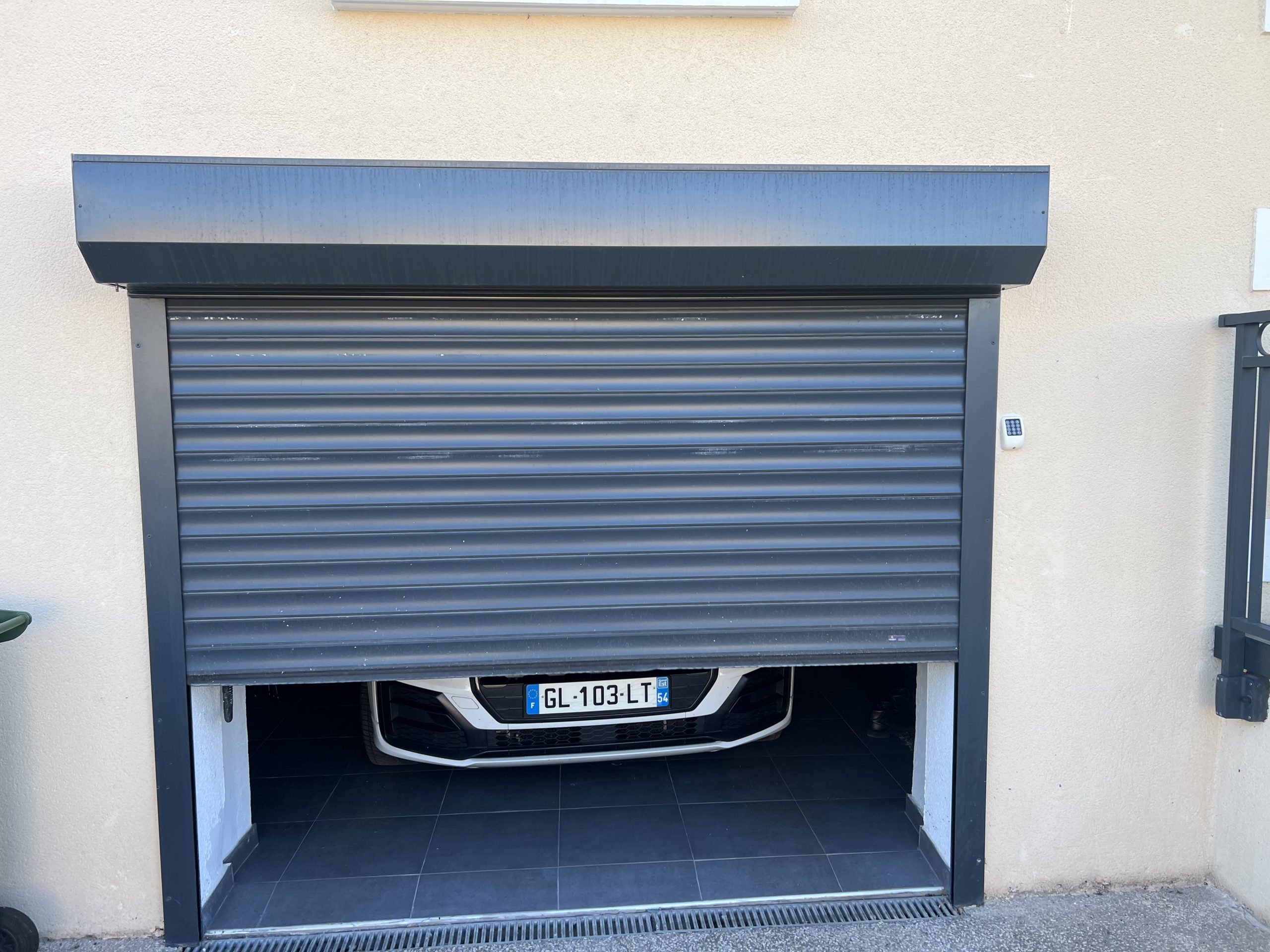 Porte de garage enroulable en aluminium laquée gris anthracite avec manoeuvre motorisée