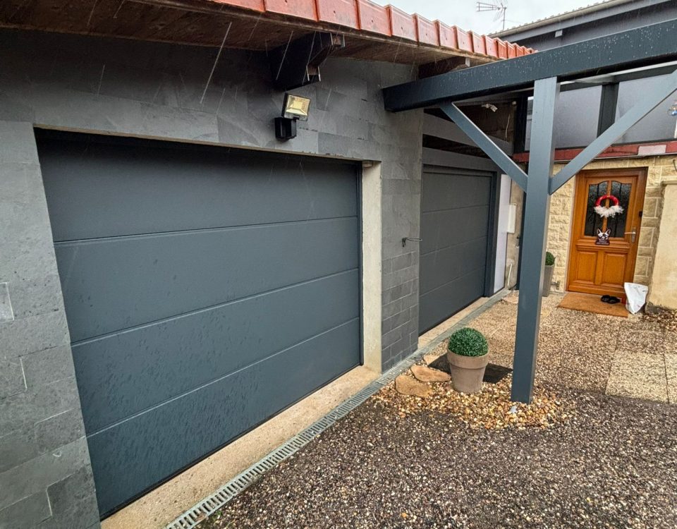 Portes de garages sectionnelles en aluminium laquées gris anthracite avec manoeuvre motorisée et design lisse