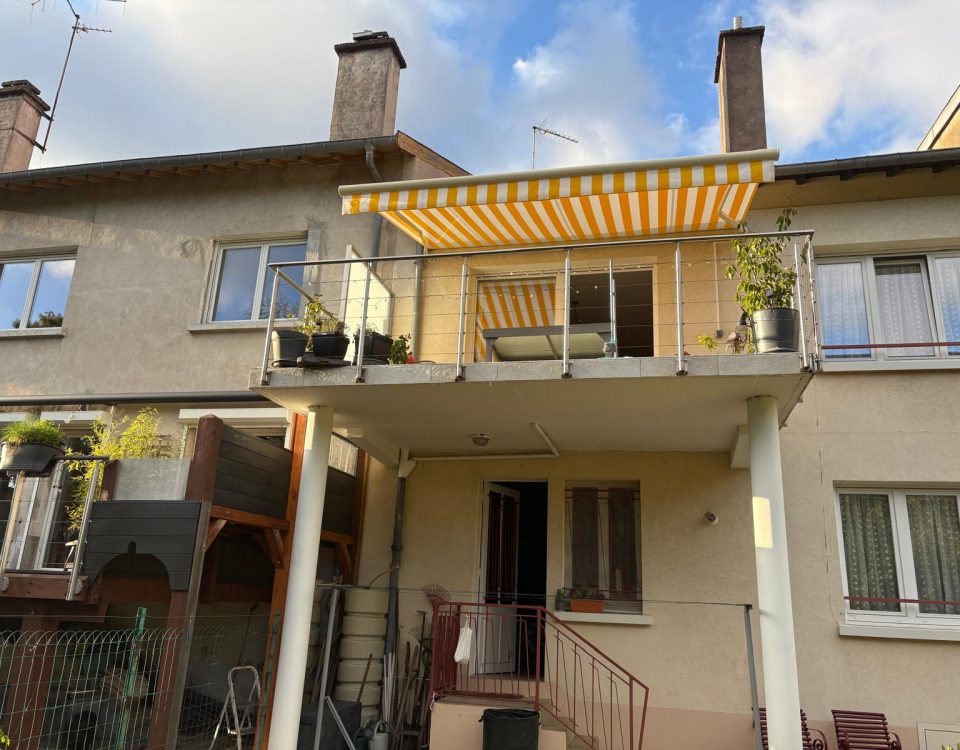 Store banne motorisé avec commande radio avec toile décorative jaune et blanche avec ossature blanche et bras avec leds intégrés