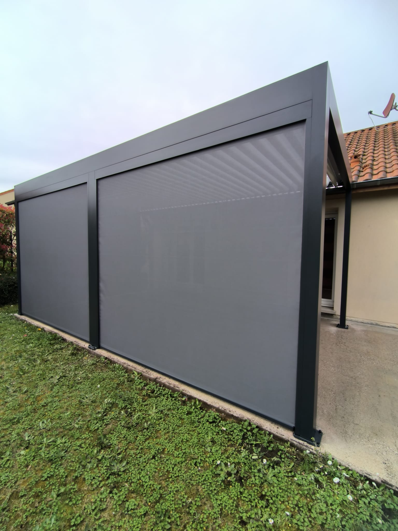 Store screen zip solaire coffre et toile Gris anthracite et pose sur pergola entre poteaux.
