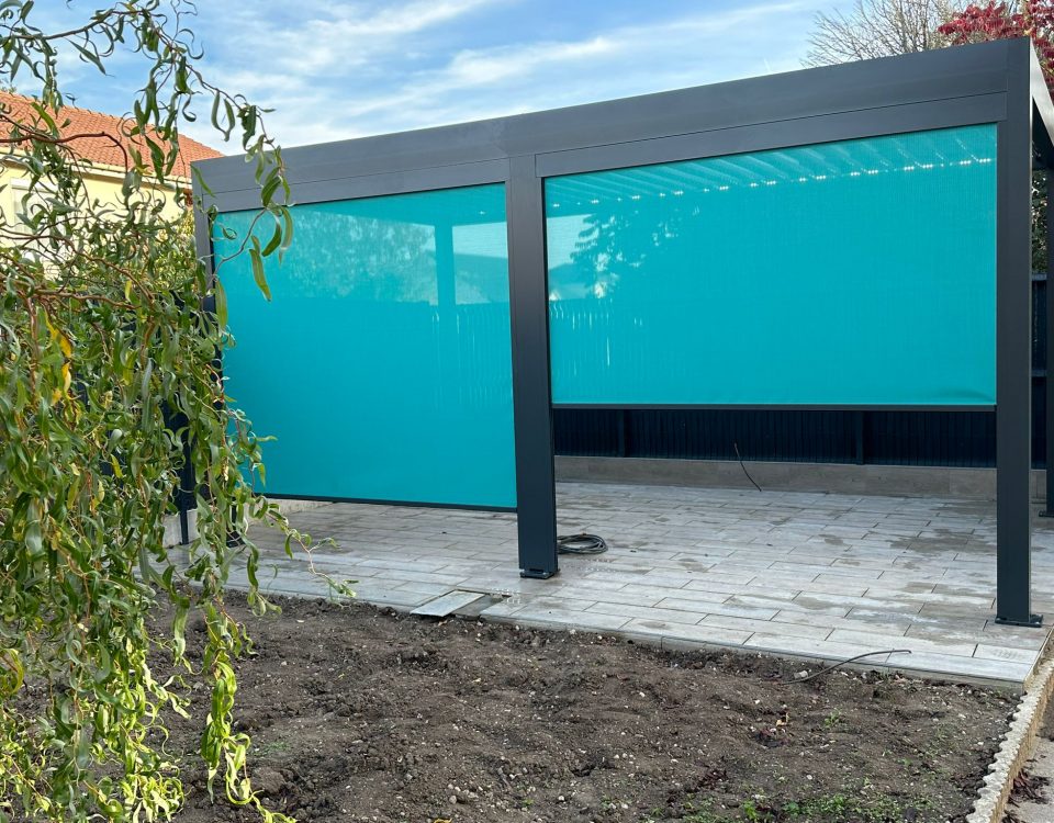 Store screen zip solaire coffre Gris anthracite et Toile Bleu turquoise et pose sur pergola entre poteaux.