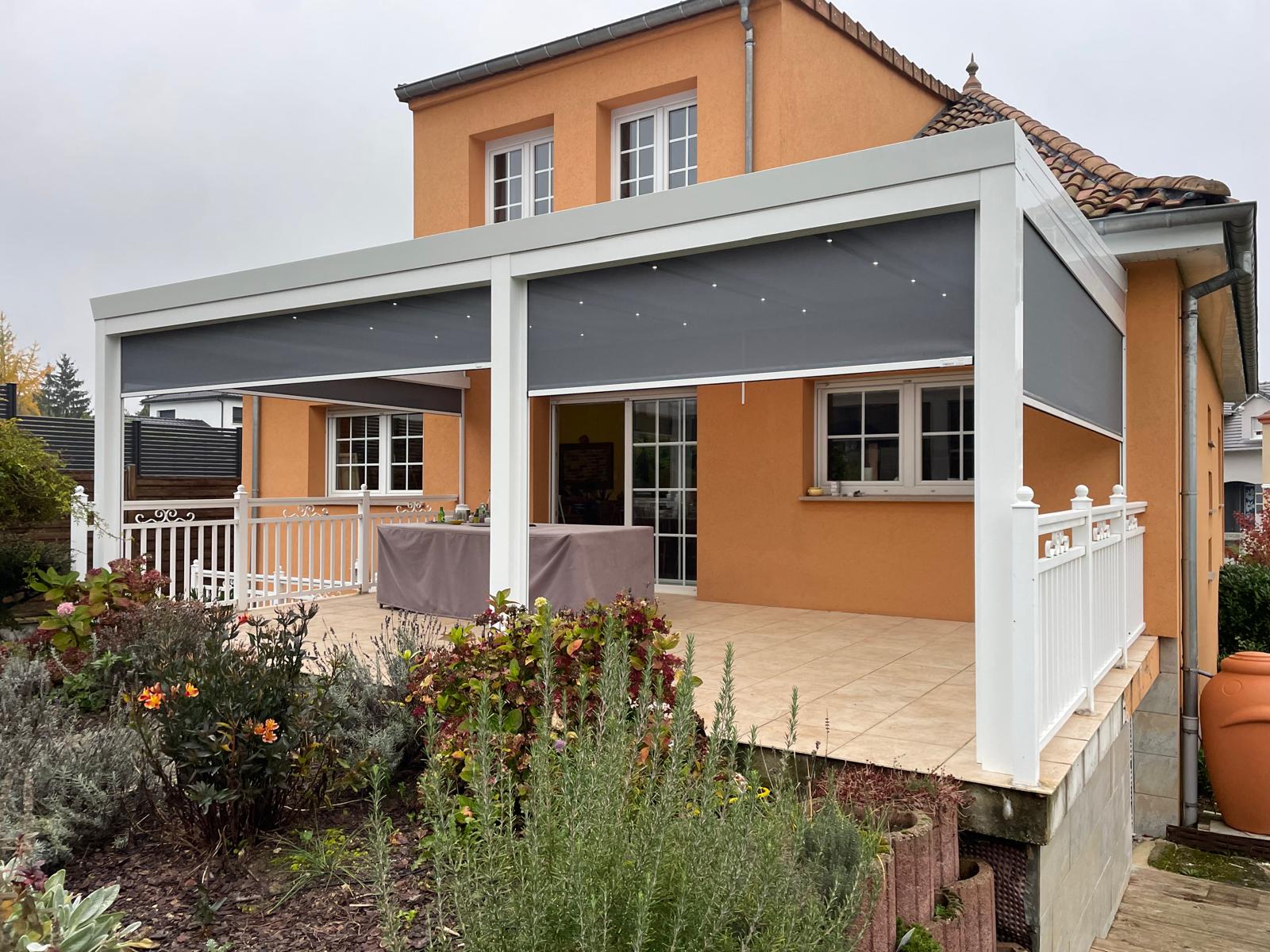 Store screen zip solaire coffre blanc et toile gris clair 9007 et pose sur pergola entre poteaux.