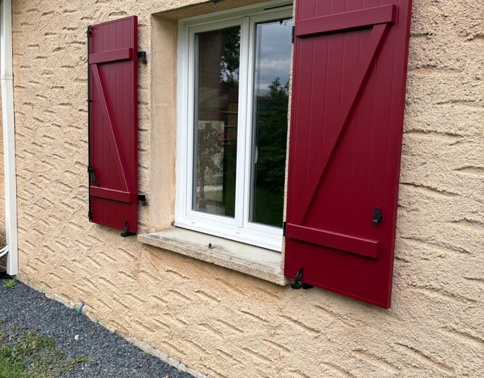 Volets battants en aluminium laqué rouge bordeaux avec une pose sur gonds existants