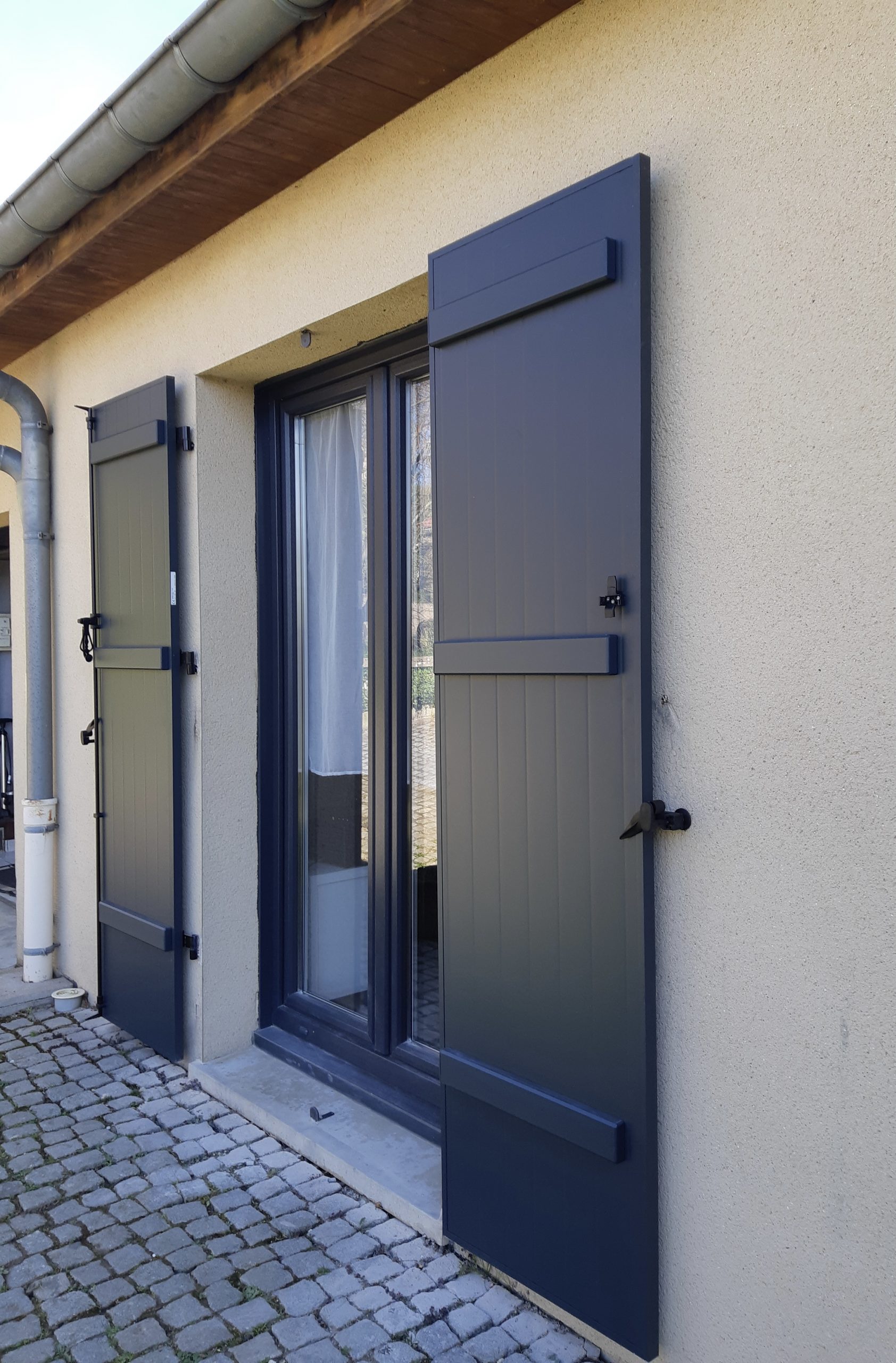 Volets battants en aluminium laqué gris anthracite avec pose sur gonds