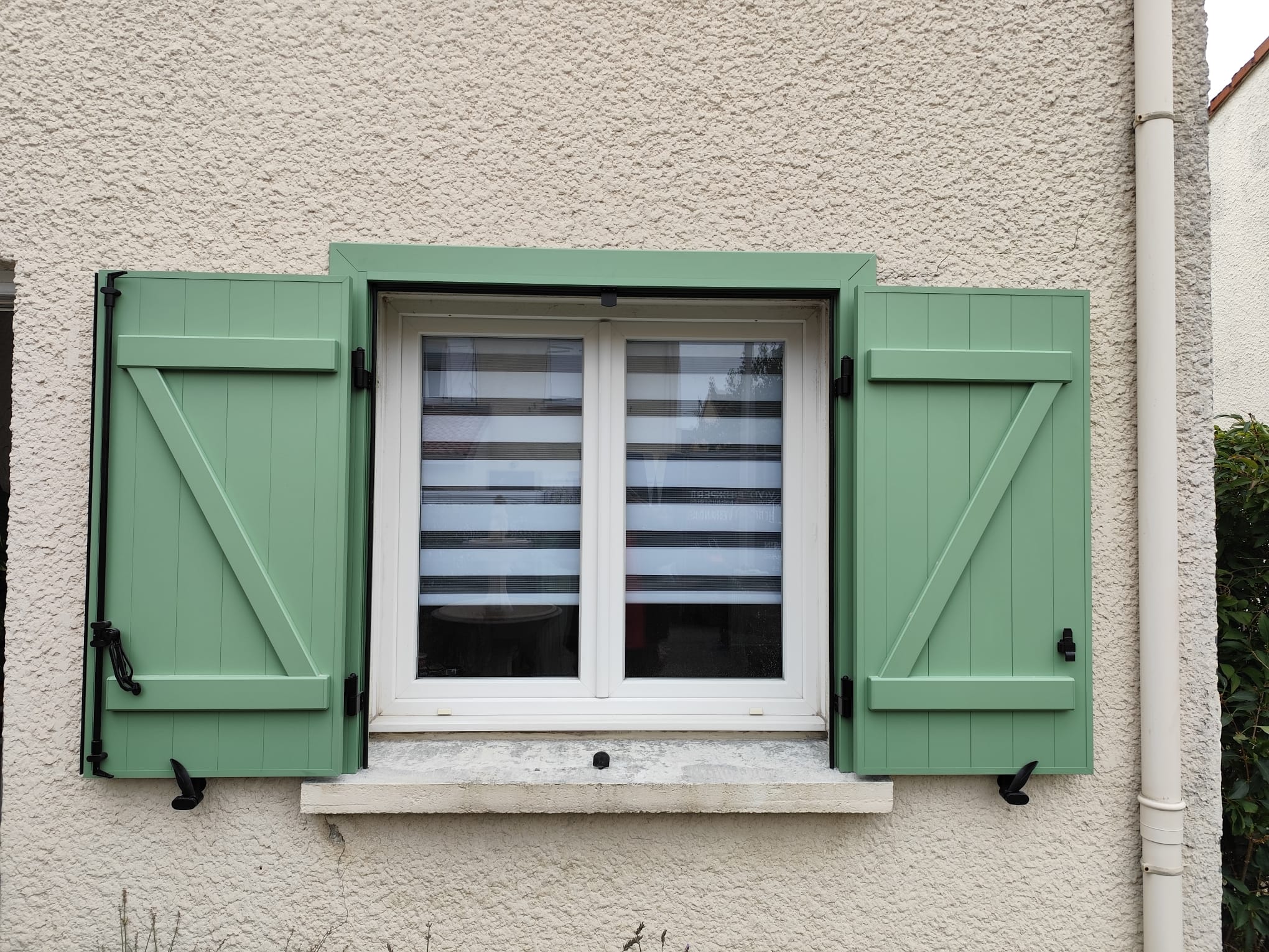 Volets battants en aluminium vert pâle avec pré cadre
