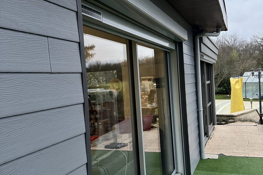 Fenêtre en aluminium laqué gris clair extérieur et blanc intérieur avec ouvrant et dormant renforcés avec volets roulants solaires