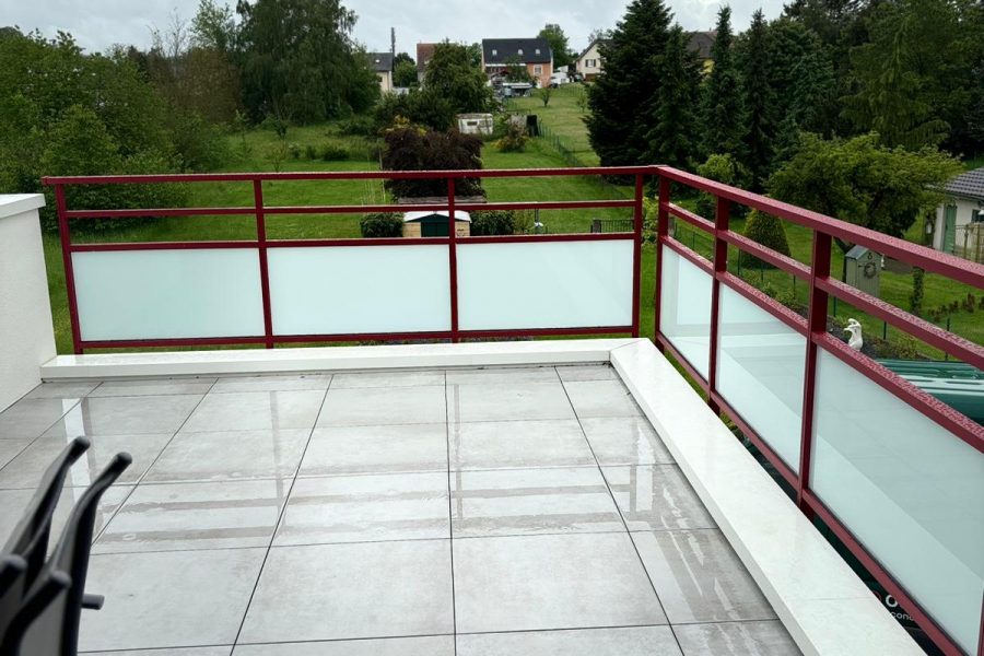 Garde corps en aluminium laqué rouge pourpre avec barreaudage verticale et horizontal avec vitrage dépoli en sous bassement et une pose sur dalle