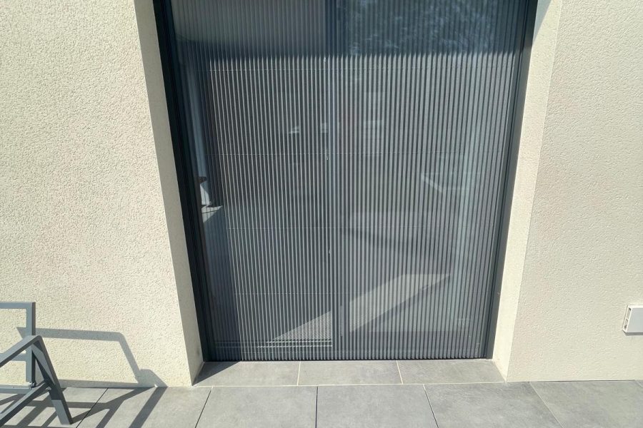 Moustiquaire plissée avec ossature en aluminium laquée gris anthracite avec toile fibre de verre grise