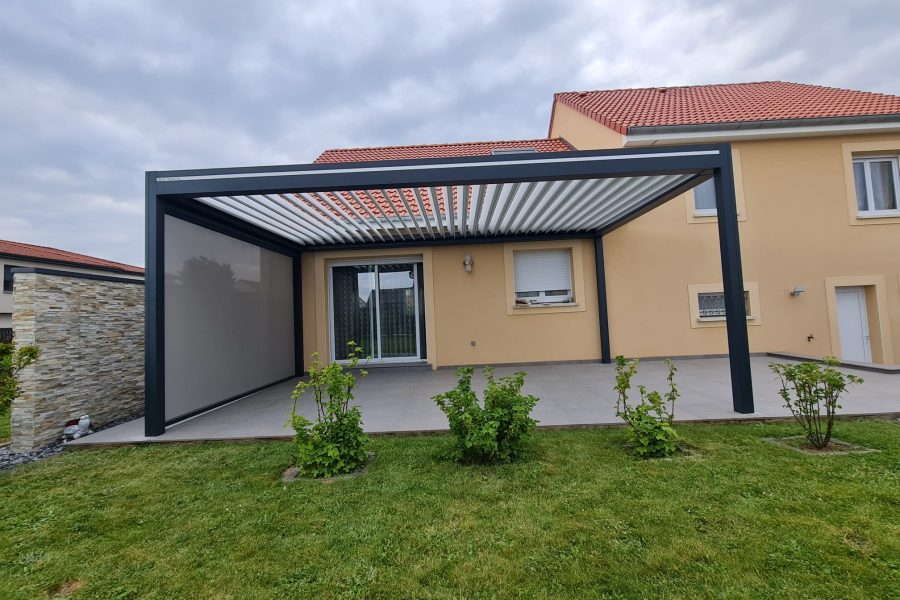Pergola bioclimatique avec ossature en aluminium gris anthracite et lames orientables blanches en aluminium avec store ZIP latéral gris anthracite intégré