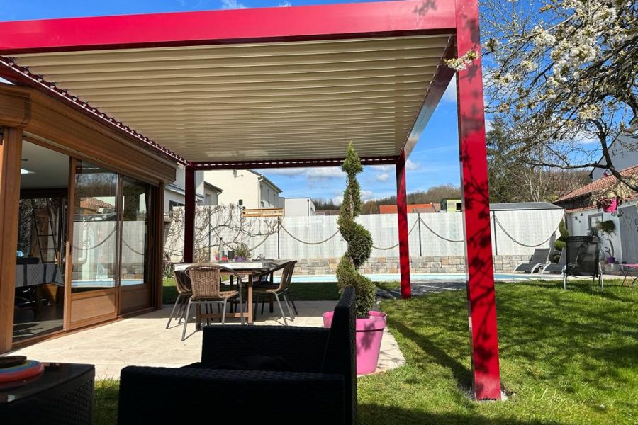 Pergola bioclimatique avec ossature en aluminium rouge avec lames orientables blanches en aluminium