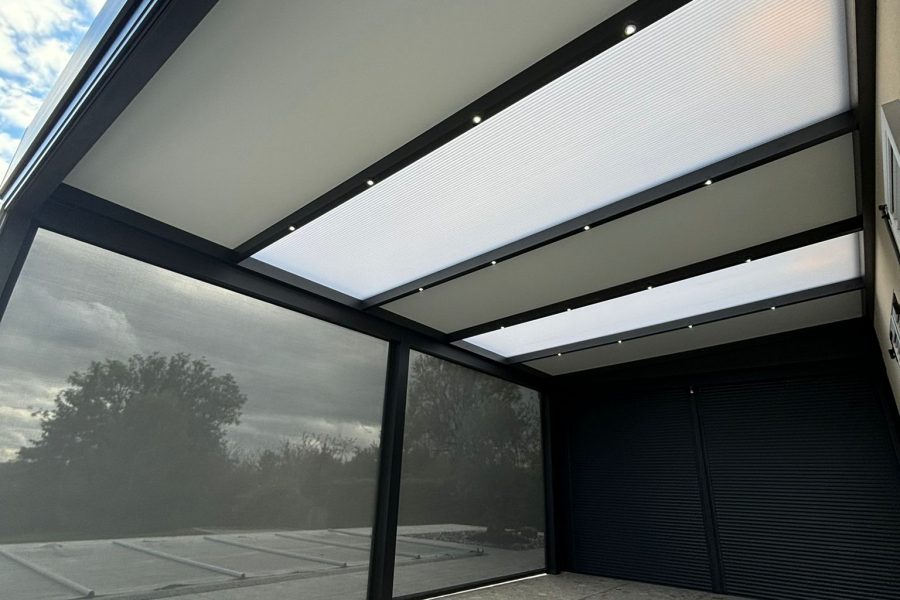 Pergola fixe avec ossature en aluminium laquée gris anthracite avec toiture panneaux sandwich et polycarbonate 32mm et stores zip intégrés