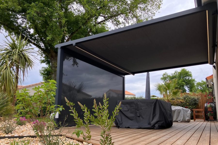Pergola store avec ossature en aluminium laqué gris anthracite avec toile grise anthracite avec bandeau led avec store gris anthracite en façade