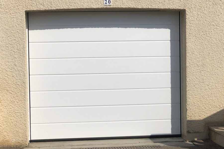 Porte de garage sectionnelle en aluminium laqué blanc avec épaisseur de 42 mm isolante avec manoeuvre motorisée et design lisse