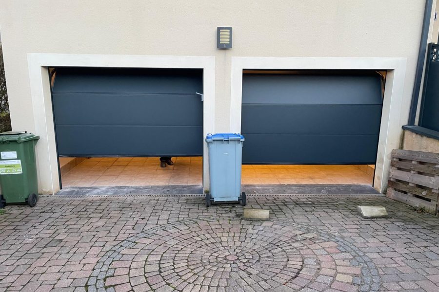 Portes de garages sectionnelles en aluminium laquées gris anthracite avec manoeuvre motorisée et design lisse