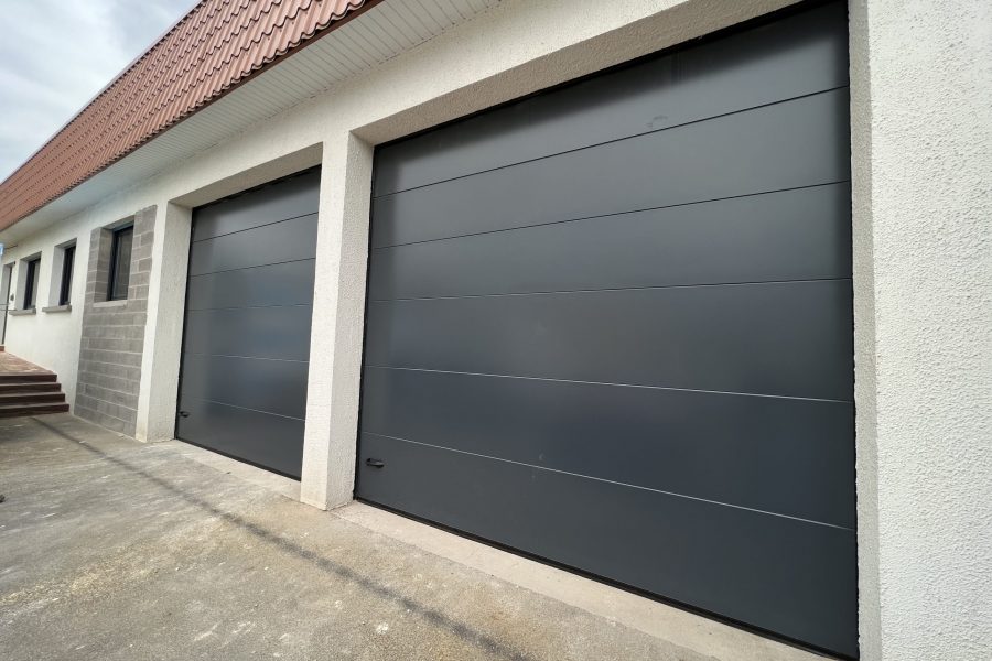 Portes de garages sectionnelles en aluminium laquées gris anthracite avec manoeuvre motorisée et design lisse